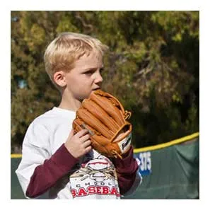 A young camper peeking over the top of his glove