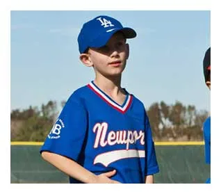 A young ballplayer standing on the field ready to play