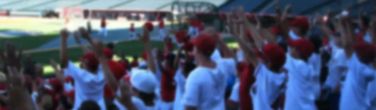 Campers in Mark Cresse shirts cheering from the stands at a pro stadium